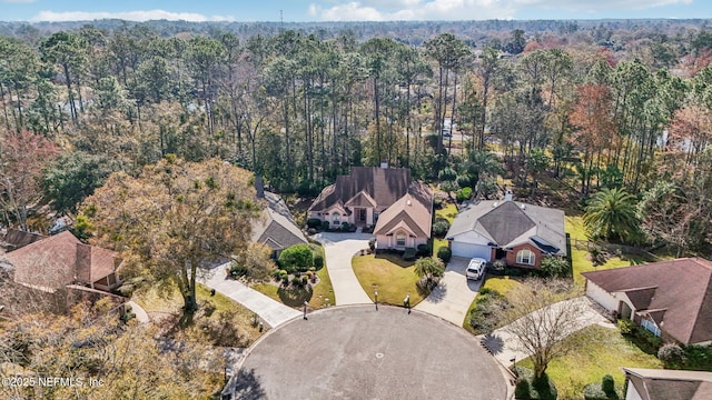 birds eye view of property featuring a forest view