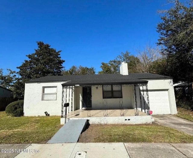 view of front of house featuring a garage, a front lawn, and a porch