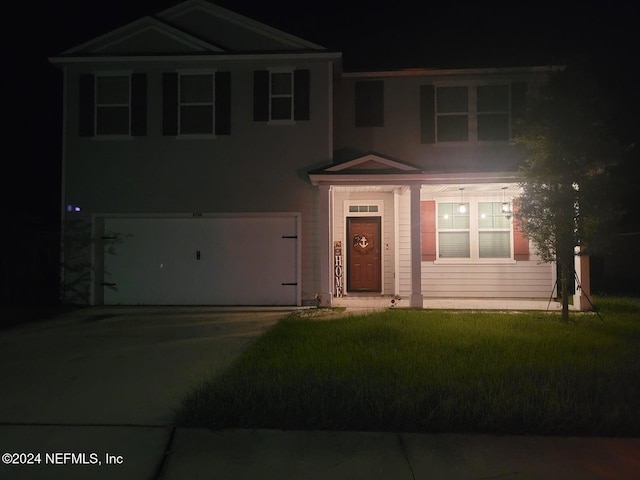 view of front facade with a garage and a yard