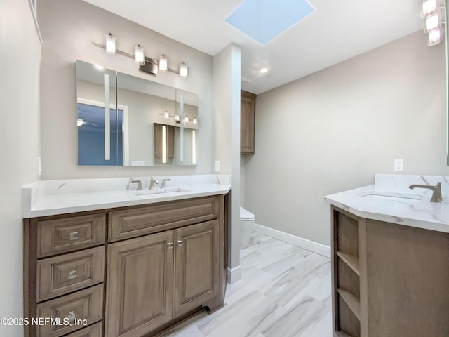 bathroom featuring a skylight, vanity, hardwood / wood-style flooring, and toilet