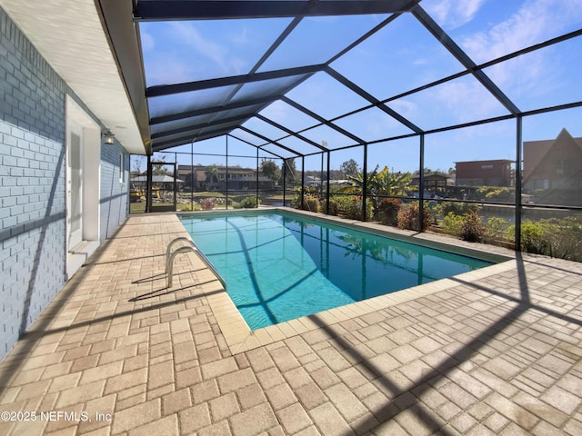 view of swimming pool featuring a lanai and a patio