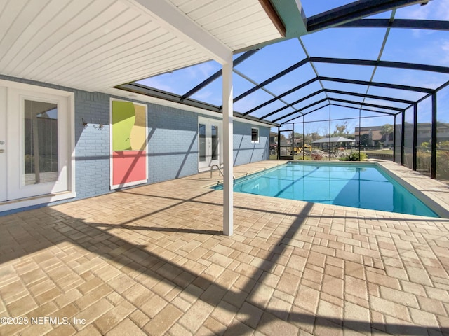 view of swimming pool with a patio and a lanai