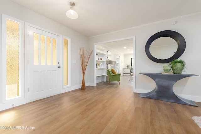 foyer entrance featuring ornamental molding and light wood-type flooring