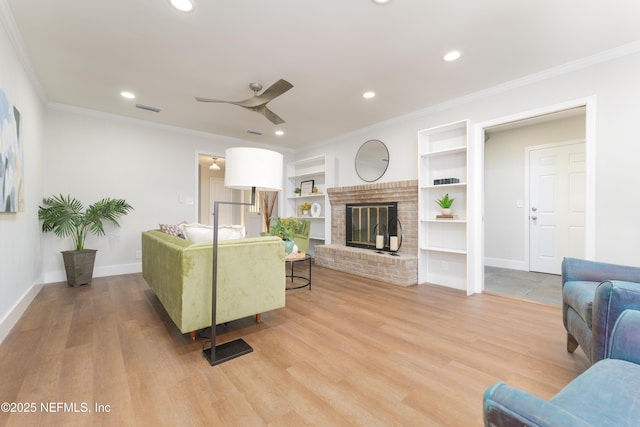 living room featuring crown molding, a brick fireplace, and wood-type flooring