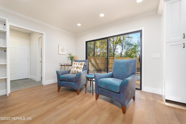 living area featuring crown molding and light wood-type flooring