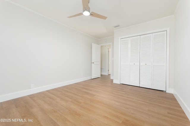 unfurnished bedroom featuring ornamental molding, a closet, and light wood-type flooring