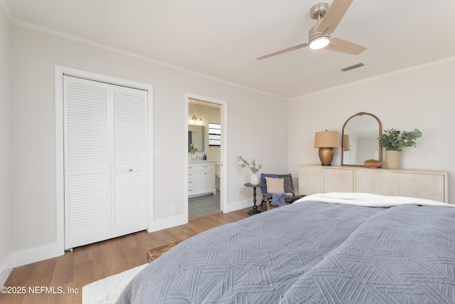 bedroom with hardwood / wood-style flooring, connected bathroom, crown molding, and a closet