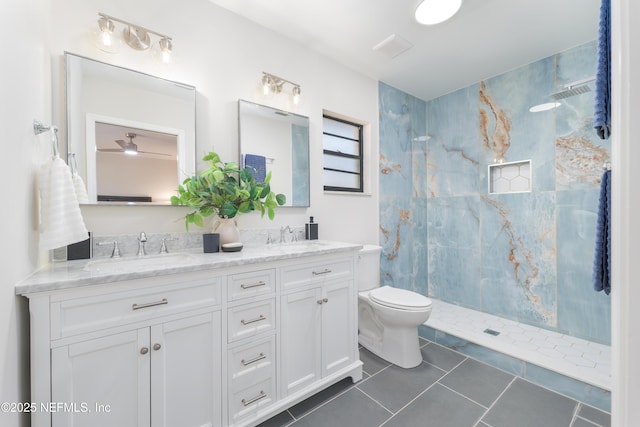 bathroom with vanity, tiled shower, tile patterned floors, and toilet