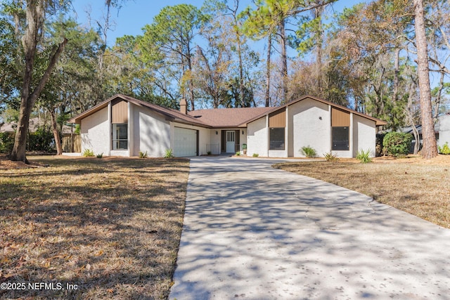 ranch-style home featuring a garage and a front yard