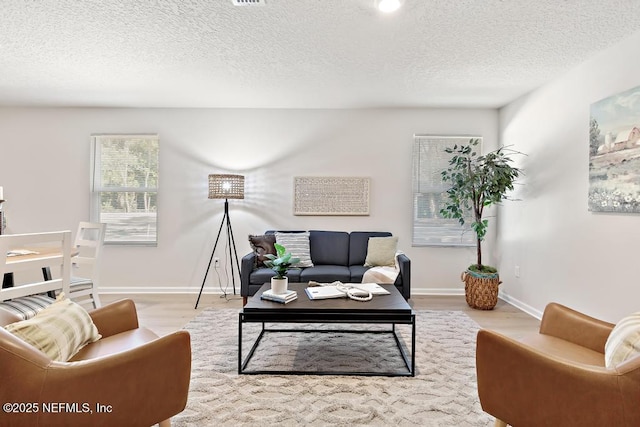 living room featuring light hardwood / wood-style flooring and a textured ceiling