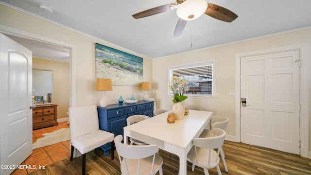 dining room with ornamental molding, dark wood-type flooring, a textured ceiling, and ceiling fan