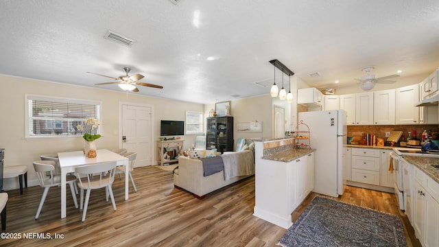 kitchen featuring white cabinetry, white appliances, dark stone counters, and pendant lighting