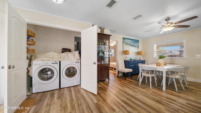 washroom with washing machine and dryer, ceiling fan, a textured ceiling, and light hardwood / wood-style floors