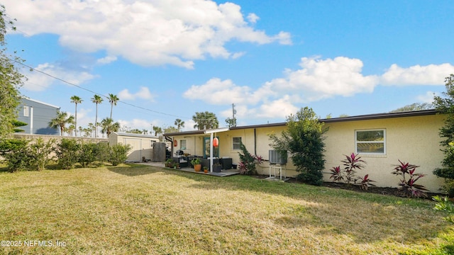 back of property featuring central AC, a storage shed, a yard, and a patio area