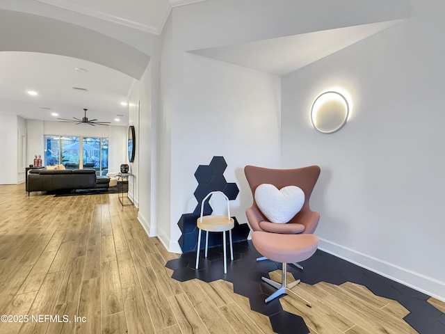 sitting room with crown molding, ceiling fan, and light wood-type flooring