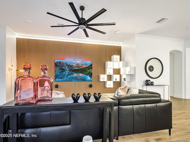 living room featuring hardwood / wood-style flooring, ornamental molding, and ceiling fan