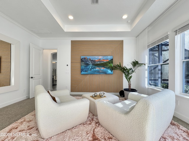 carpeted living room with crown molding, plenty of natural light, and a tray ceiling