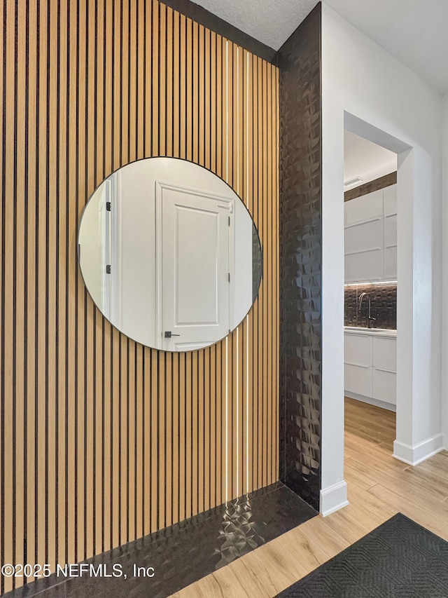 interior details with hardwood / wood-style flooring, sink, and decorative backsplash