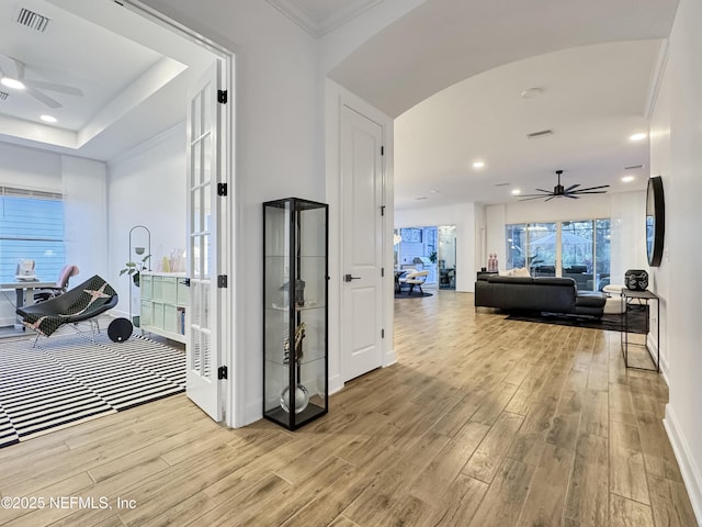 corridor featuring ornamental molding and light hardwood / wood-style floors