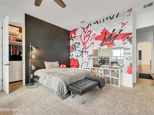 carpeted bedroom with ceiling fan and a closet