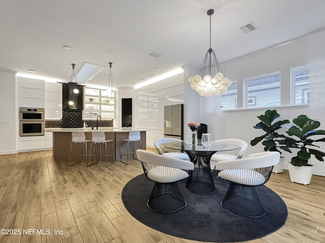 dining area featuring sink and light wood-type flooring