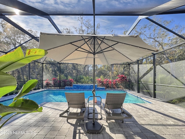 view of pool with a patio and glass enclosure