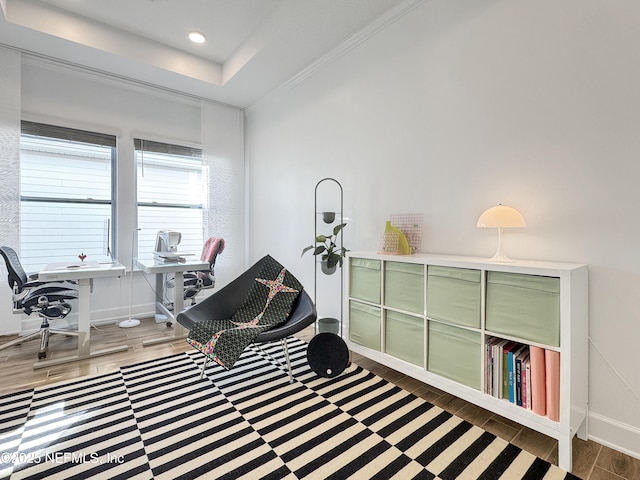 living area featuring crown molding, wood-type flooring, and a tray ceiling