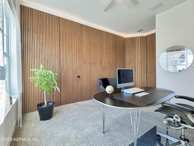 office with ceiling fan, wooden walls, and a textured ceiling