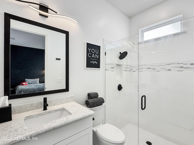 bathroom featuring an enclosed shower, vanity, and toilet