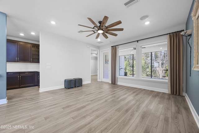 unfurnished living room featuring ceiling fan and light wood-type flooring