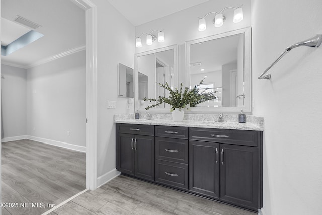 bathroom with vanity, hardwood / wood-style flooring, and crown molding