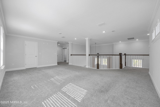 unfurnished room featuring ornate columns, ornamental molding, and carpet flooring