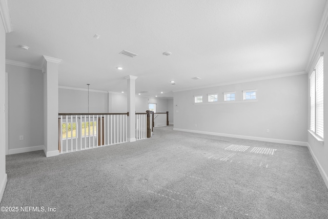 carpeted empty room with crown molding and ornate columns