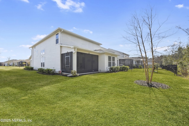 rear view of property featuring a sunroom and a yard