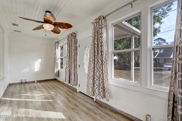 unfurnished room with wood ceiling, light hardwood / wood-style flooring, ceiling fan, and brick wall