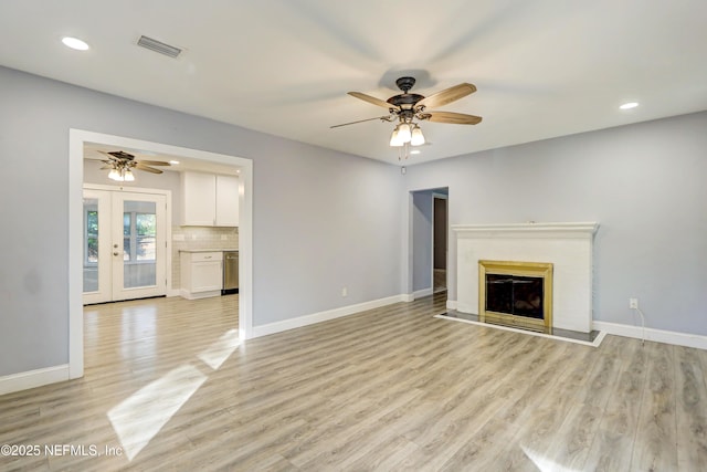 unfurnished living room with french doors, ceiling fan, and light hardwood / wood-style floors