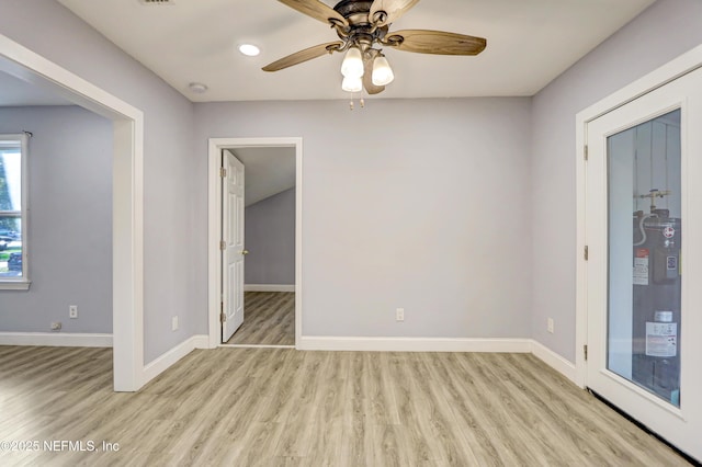 empty room with ceiling fan, electric water heater, and light wood-type flooring