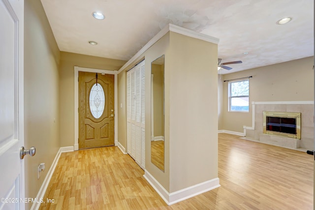 entryway with a premium fireplace, ceiling fan, and light hardwood / wood-style floors