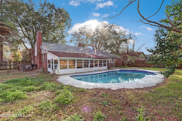 view of swimming pool featuring a sunroom