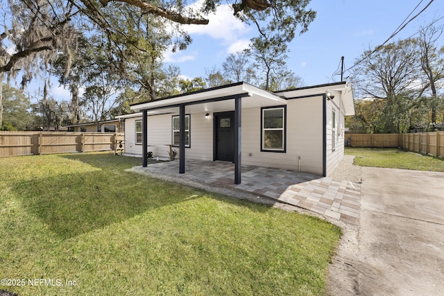 rear view of house with a yard and a patio area