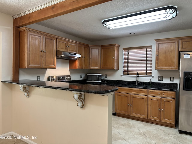 kitchen with sink, stainless steel appliances, a breakfast bar, and kitchen peninsula