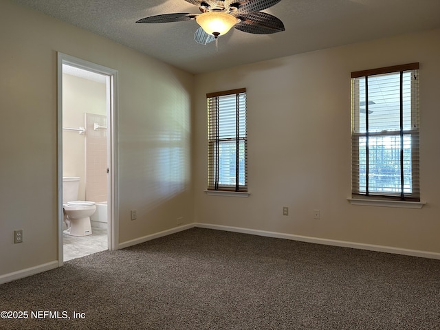 unfurnished bedroom featuring ensuite bathroom, carpet, a textured ceiling, and ceiling fan