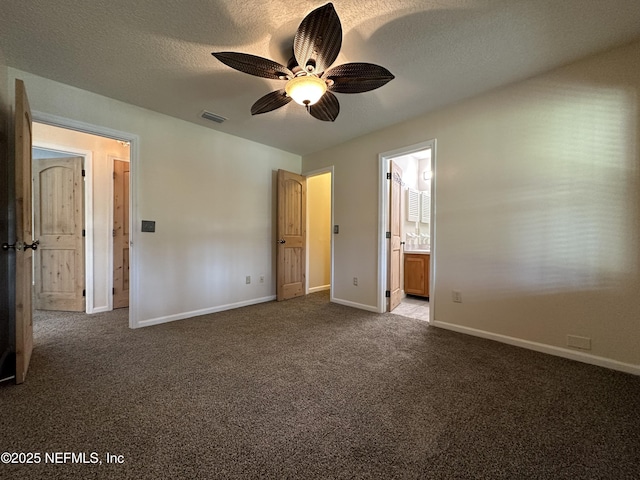 unfurnished bedroom featuring ceiling fan, carpet, a textured ceiling, and ensuite bath