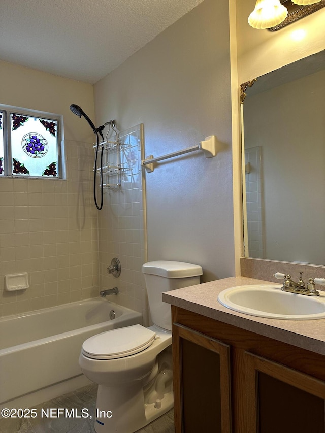 full bathroom with vanity, a textured ceiling, toilet, and tiled shower / bath