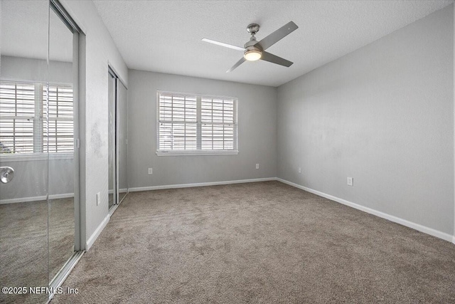 unfurnished bedroom with ceiling fan, carpet, and a textured ceiling