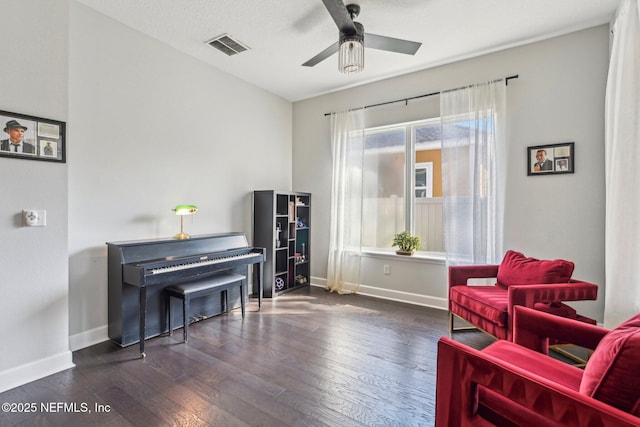 living area with dark wood-type flooring and ceiling fan