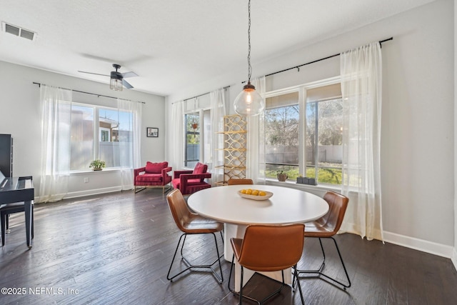 dining room featuring dark wood-type flooring, a textured ceiling, and ceiling fan