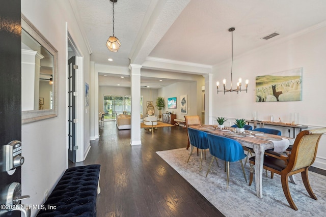 dining space with crown molding, an inviting chandelier, dark hardwood / wood-style floors, a textured ceiling, and ornate columns