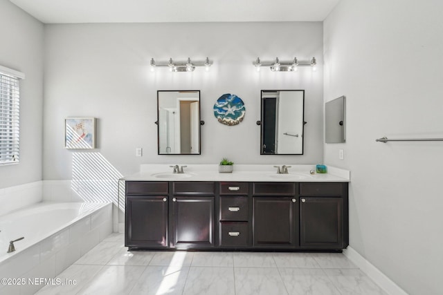 bathroom featuring vanity and tiled bath