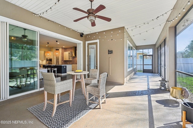 sunroom / solarium with a healthy amount of sunlight, track lighting, and ceiling fan